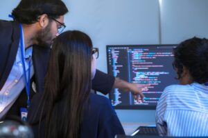 Software developers reviewing source code in front of a computer.
